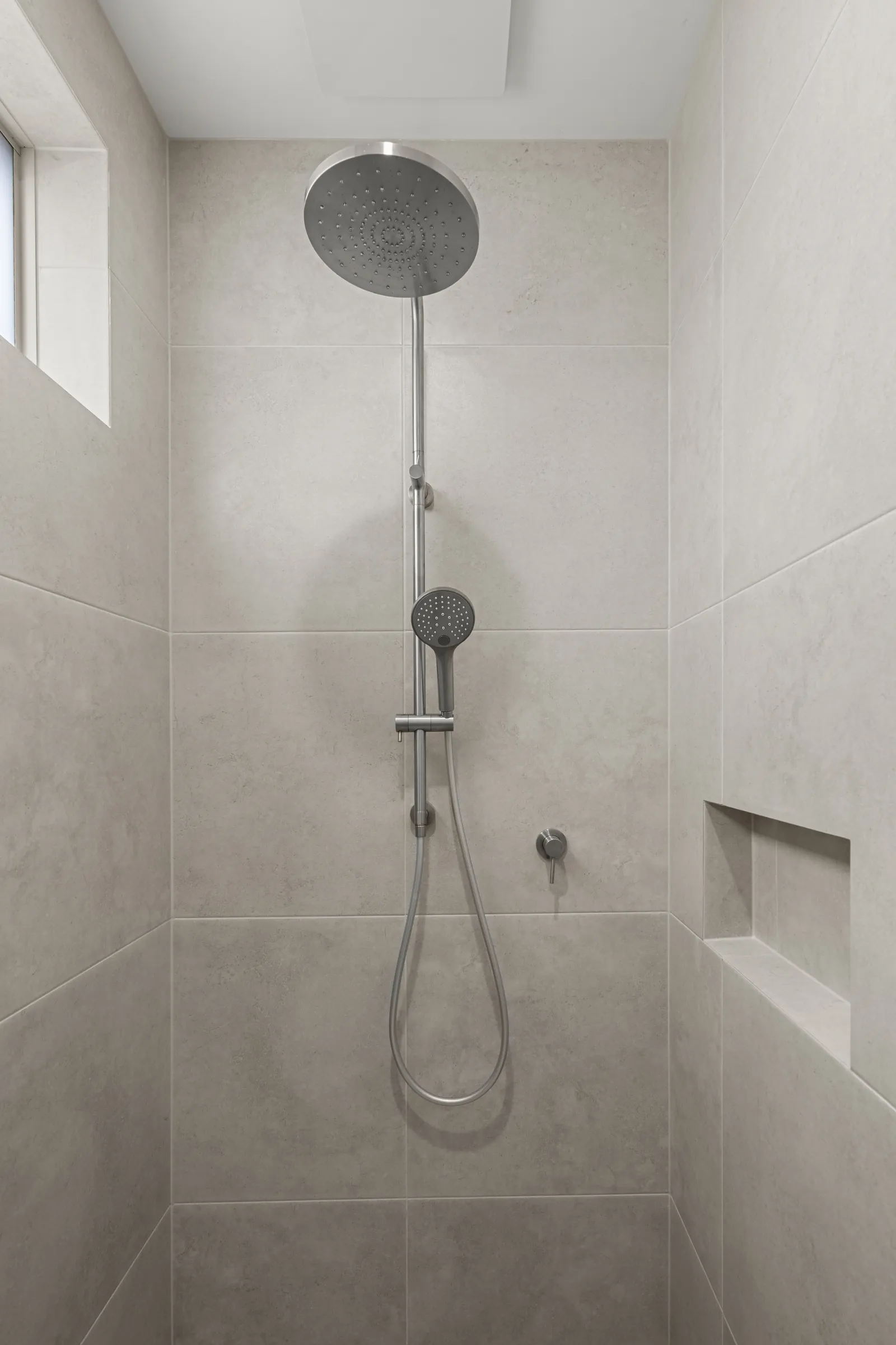 Rain shower with a hand shower and tiled niche
