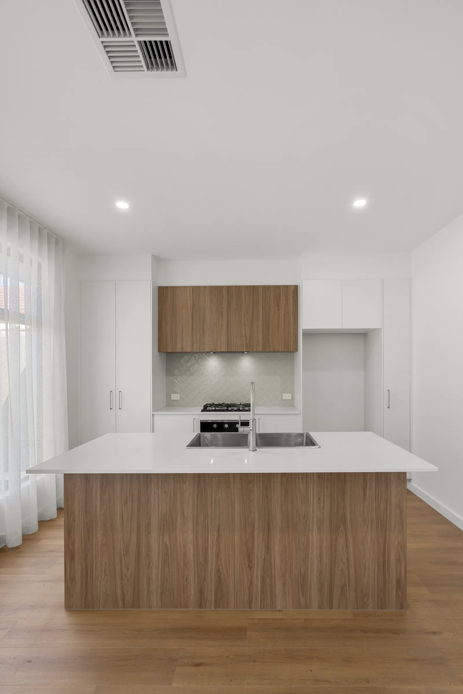 Kitchen island and overhead cabinetry in a new Queenstown home