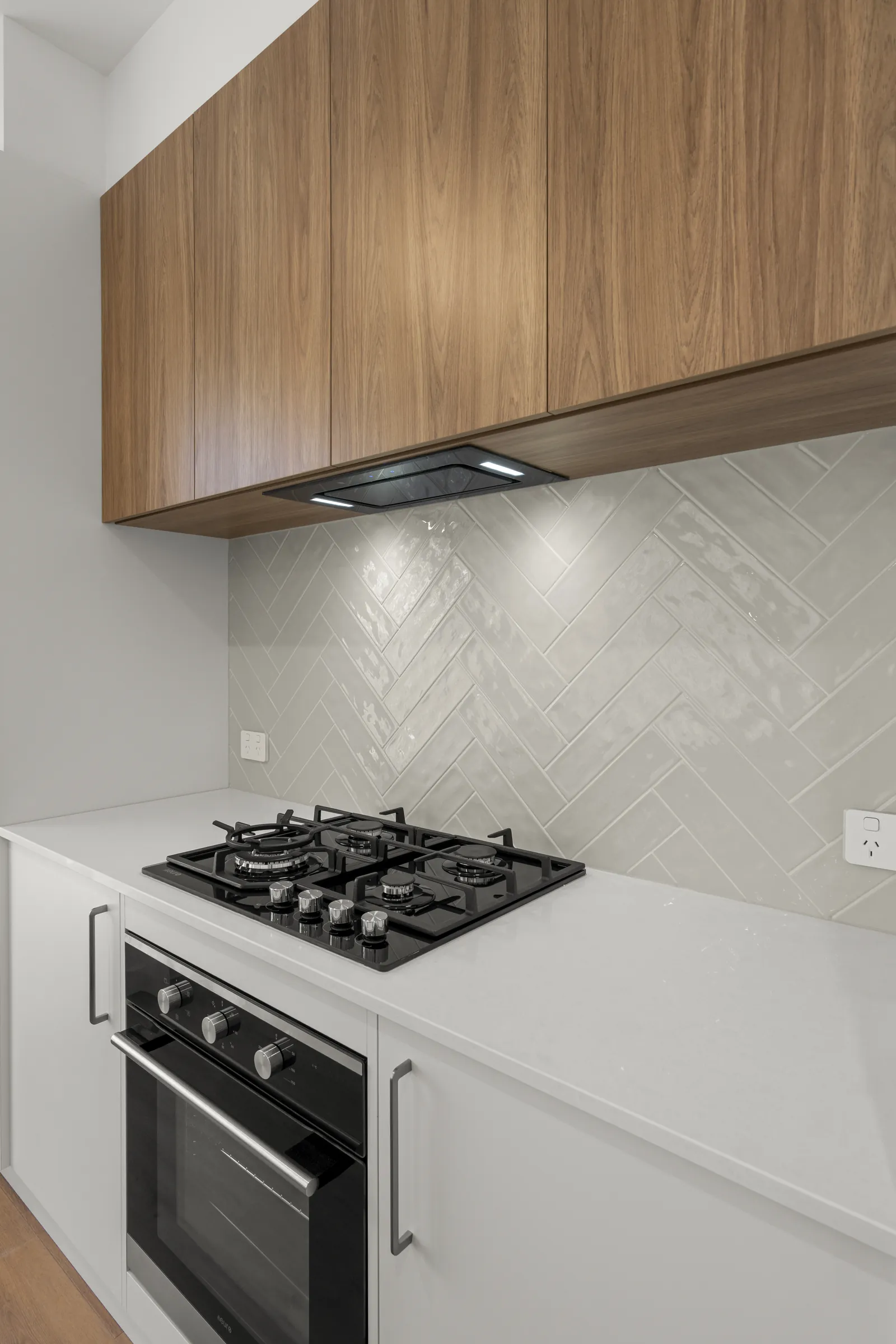 Gas cooktop, built-in oven and rangehood in a new kitchen